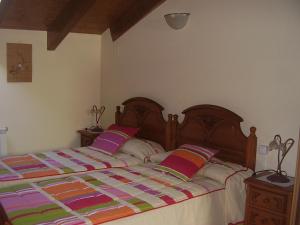 a bedroom with a large bed with a colorful quilt at Casa Magí in Vilaller