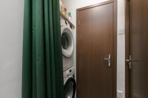 een badkamer met een deur en een wasmachine bij Stone Gate Apartment #2 in Boekarest