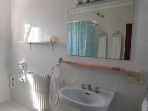 y baño con lavabo, espejo y toallas. en Hostal Sa Barraca - Adults Only en Begur