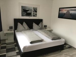 um quarto com uma cama com uma cabeceira preta em AAA FeWo Bad Gastein/Böckstein em Bad Gastein