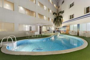 a swimming pool in the middle of a building at Ramada Qurum Beach Hotel in Muscat