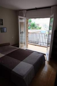 a bedroom with a bed and a large window with a balcony at Flat near Lloret De Mar center and beach in Lloret de Mar