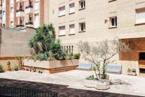 a courtyard with benches and plants in front of a building at Flat near Lloret De Mar center and beach in Lloret de Mar