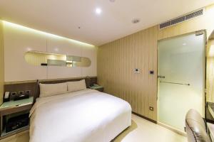 1 dormitorio con cama blanca y puerta corredera en Beauty Hotels - Hotel Bnight-Self Check-In Hotel, en Taipéi