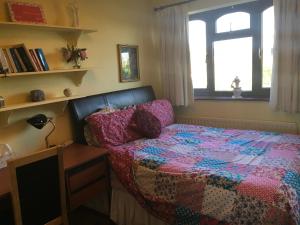 um quarto com uma cama, uma secretária e uma janela em The Cedars House B&B em Nuneaton