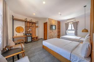a bedroom with two beds and a living room at Coast House Boutique Hotel in Nha Trang