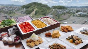 uma mesa coberta com bandejas de diferentes tipos de alimentos em Sabae City Hotel em Sabae