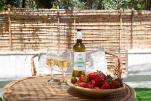 een fles wijn en twee glazen op een tafel met aardbeien bij Don Bruno Homes in Amendolara