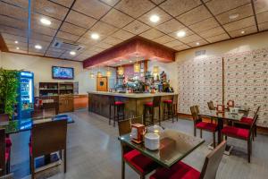 a restaurant with tables and chairs and a bar at Hotel Ciudad de Martos in Martos