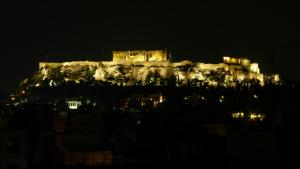 a castle on top of a mountain at night at Evripides Hotel in Athens