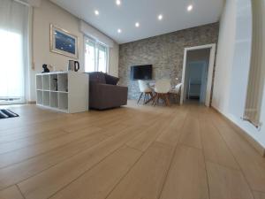 un soggiorno con pavimento in legno e divano. di Le Rive a Desenzano del Garda