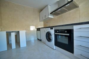 uma cozinha com máquina de lavar e secar roupa em Apartamentos Barrio Húmedo Catedral 2 em Leão