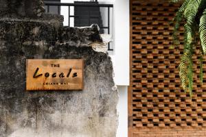 um sinal que diz que o homem de tinta local numa parede em The Locals Chiang Mai em Chiang Mai