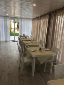 una lunga sala da pranzo con tavoli, sedie e finestre di Vista beb mare a Manfredonia