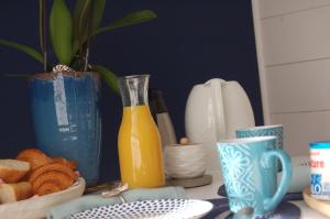 un tavolo con una brocca di succo d'arancia e una ciotola di pane di L'Abri du Marin ad Audierne