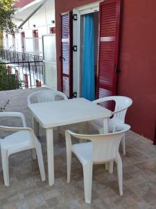 faliraki apartments في بينيتسيس: طاولة بيضاء وكراسي على الفناء