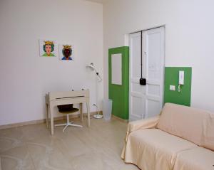 ein Wohnzimmer mit einem Sofa und einem Schreibtisch in der Unterkunft MOKARTA B&B in Catania