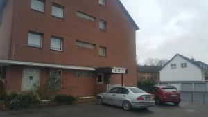 two cars parked in front of a brick building at Hotel Heideklause in Cologne