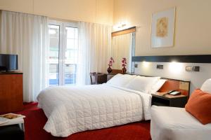 ein Hotelzimmer mit 2 Betten und einem TV in der Unterkunft Victory Inn in Athen