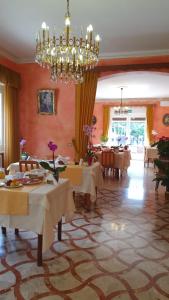 a dining room with tables and a chandelier at Apartment Lake Maggiore - Gelsomino in Maccagno Inferiore
