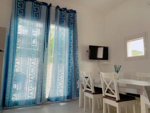 a dining room with blue curtains and a table and chairs at Casa Montecristo in Marina di Campo