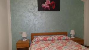 um quarto com uma cama e duas mesas de cabeceira com candeeiros em Apartment Lake Maggiore - Gelsomino em Maccagno Inferiore