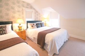 a bedroom with two beds and two windows at Ennislare House Guest Accommodation in Bangor