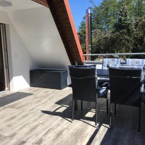 a patio with a table and chairs on a deck at Ferienwohnung Möckel in Struppen