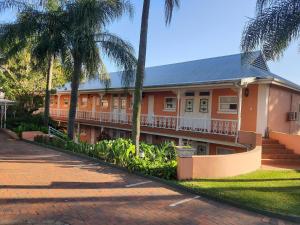 uma casa com palmeiras em frente em Sica's Guest House em Durban