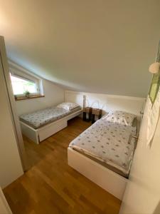 1 dormitorio con 2 camas y ventana en 5-Sterne Active Ferienwohnung Chiemgau en Marquartstein