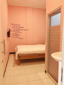 a bedroom with a bed with writing on the wall at RoomZ Budget Residence in Semarang