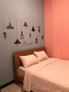 a bedroom with a bed and some lamps on the wall at RoomZ Budget Residence in Semarang