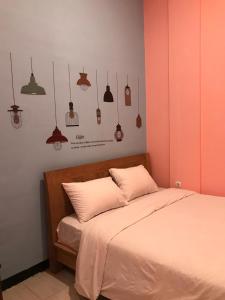 ein Schlafzimmer mit einem Bett und ein paar Lampen an der Wand in der Unterkunft RoomZ Budget Residence in Semarang