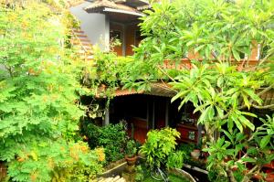 eine Außenansicht eines Hauses mit Bäumen und Pflanzen in der Unterkunft Candra Asri Bungalow in Ubud