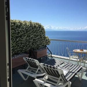 - un balcon avec deux chaises et une table donnant sur l'océan dans l'établissement Hotel Bellevue Suite, à Amalfi