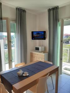 a dining room with a table and a tv at Casa VerdeMare in Porto Recanati