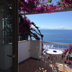 uma mesa e cadeiras numa varanda com vista para o oceano em Hotel Bellevue Suite em Amalfi