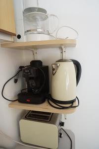 a coffee maker and a blender on a shelf at Alexandra Vendégház Siófok in Siófok