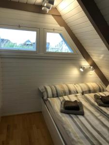 two beds in a room with two windows at Pfahlbau Neusiedlersee - Waterfront - erste Reihe in Rust