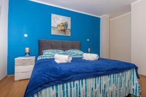 a blue bedroom with a bed with blue walls at Apartmani Jasminka in Dramalj