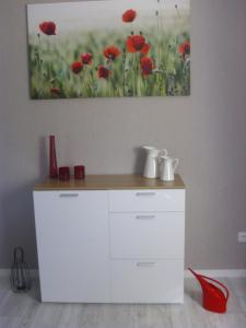 un armario blanco con zapatos rojos y una pintura en la pared en Haus Mühlenbach, en Mechernich