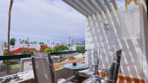 プラヤ・デ・ラス・アメリカスにあるBeach Life 365 Apartmentのバルコニー(テーブル、椅子付)、窓が備わります。