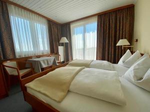 a hotel room with a large bed and a table at Pension Seirer in Sankt Radegund bei Graz