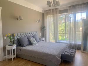 a bedroom with a bed and a large window at PRIVATE ELITE VILLA IN JURMALA in Jūrmala