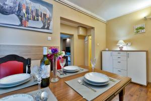 a dining room with a table with plates and wine glasses at Apartman Jura, dvije spavaće sobe in Sveti Ivan Zelina