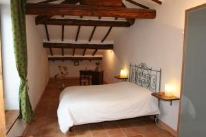 a bedroom with a white bed and wooden ceilings at B&B La Coperta Ricamata in Siena