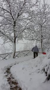 a person walking through snow with a snow shovel at Locanda San Francesco in Montecarotto