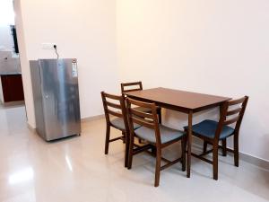 a table and chairs and a refrigerator in a kitchen at Chippy Apartments No23 in Chennai