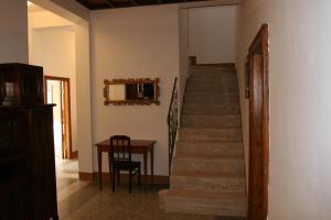 a hallway with a staircase with a table and a mirror at B&B La Coperta Ricamata in Siena
