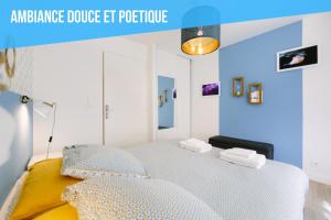 a blue and white bedroom with a bed with two towels at Appartistic - Appartement des artistes in Nantes